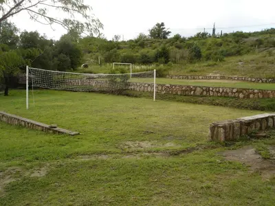 a soccer field with a net in the grass at Complejo Lago Chico in Tanti