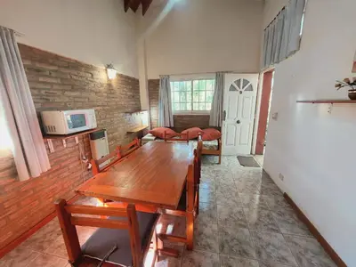 a living room with a wooden table in a room at Complejo Lago Chico in Tanti