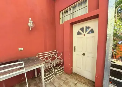 a red room with a white door and a bench at Complejo Lago Chico in Tanti