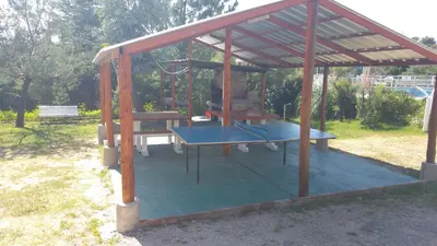 a gazebo with a table and a swing at Complejo Lago Chico in Tanti