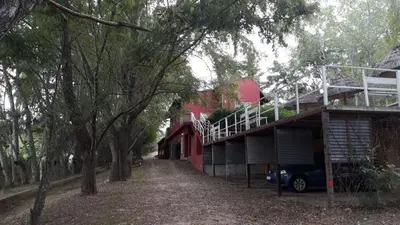a house with a car parked in front of it at Complejo Lago Chico in Tanti