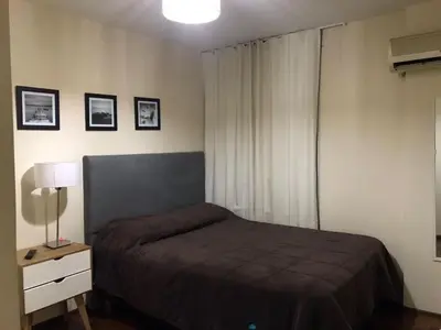 a bedroom with a bed and a lamp and a window at Pueyrredon045 in Cordoba
