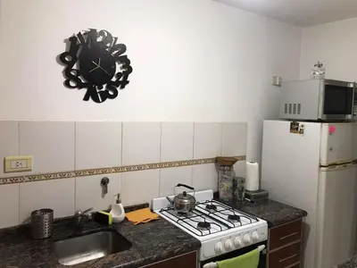 a kitchen with a stove and a clock on the wall at Pueyrredon045 in Cordoba