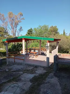 a shelter with a picnic table and a bench at Mafalda in Tanti