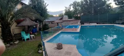 a swimming pool in a yard with a blue pool at Santa Rosa Cabañas in Santa Rosa de Calamuchita