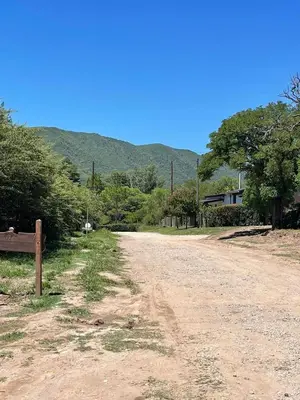 a dirt road with a bench and mountains in the background at Santa Rosa Cabañas in Santa Rosa de Calamuchita