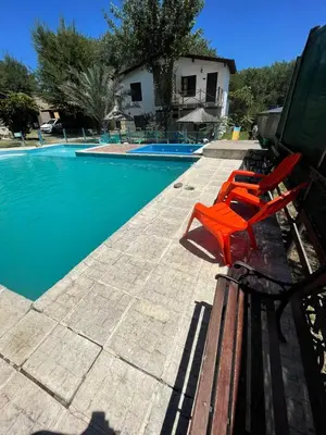 a pair of red chairs sitting next to a swimming pool at Santa Rosa Cabañas in Santa Rosa de Calamuchita