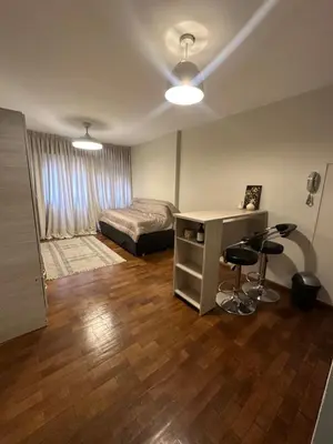 a bedroom with a bed and a desk with two stools at Moderno mono ambiente in Cordoba