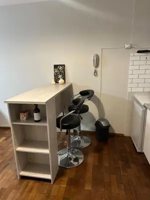 a table and two stools in a room at Moderno mono ambiente in Cordoba