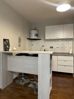 a kitchen with white cabinets and a counter top at Moderno mono ambiente in Cordoba