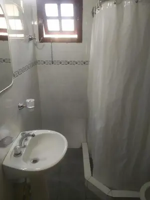 a bathroom with a sink and a shower curtain at Los abuelos in Santa Rosa de Calamuchita