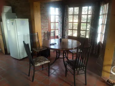 a kitchen with a table and chairs and a refrigerator at Los abuelos in Santa Rosa de Calamuchita