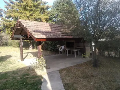 a picnic shelter with a table in a yard at Los abuelos in Santa Rosa de Calamuchita