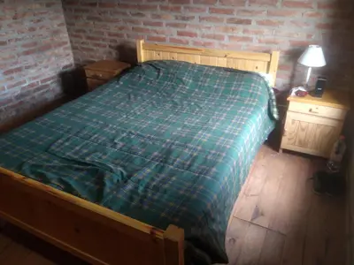 a bedroom with a bed and a brick wall at Los abuelos in Santa Rosa de Calamuchita