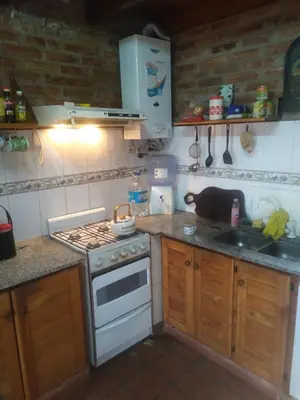 a small kitchen with a stove and a sink at Los abuelos in Santa Rosa de Calamuchita