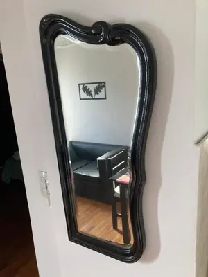 a mirror on a wall with a chair in it at Departamento Juniors in Cordoba