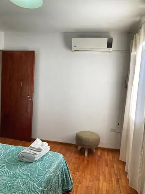 a bedroom with a bed and a ottoman and a air compressor at Departamento Juniors in Cordoba