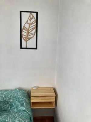 a bedroom with a bed and a wooden nightstand at Departamento Juniors in Cordoba