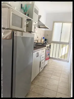 a kitchen with a stainless steel refrigerator and a microwave at Departamento Juniors in Cordoba
