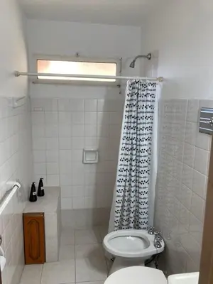 a bathroom with a toilet and a shower curtain at Departamento Juniors in Cordoba