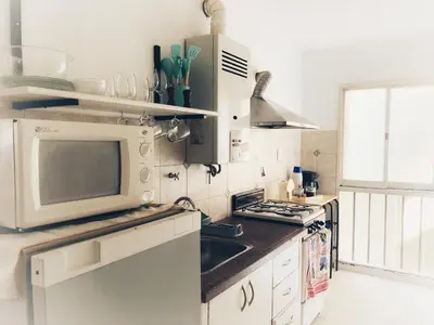 a kitchen with a microwave and a stove top oven at Departamento Juniors in Cordoba