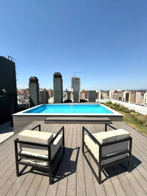 two chairs and a table on a roof with a pool at Petit Premium Nueva Cba - Oulton in Cordoba