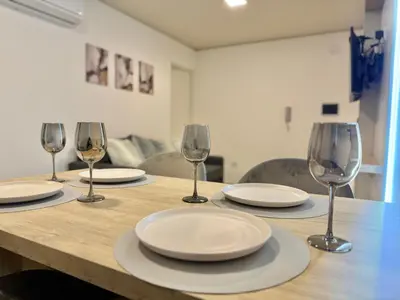a wooden table with plates and wine glasses on it at Petit Premium Nueva Cba - Oulton in Cordoba