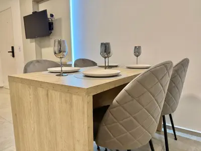 a wooden table with chairs and wine glasses on it at Petit Premium Nueva Cba - Oulton in Cordoba