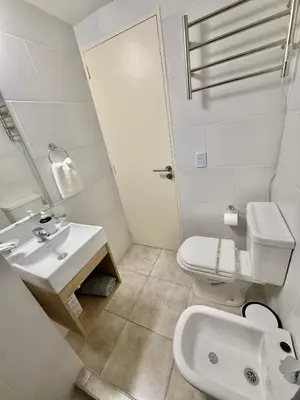 a white bathroom with a sink and a toilet at Petit Premium Nueva Cba - Oulton in Cordoba