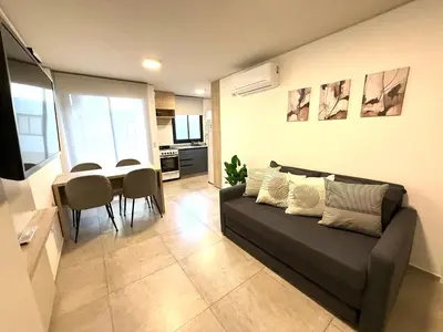 a living room with a couch and a table at Petit Premium Nueva Cba - Oulton in Cordoba