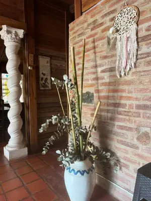 a white vase with flowers in it next to a brick wall at La casa de Pedro in San Roque