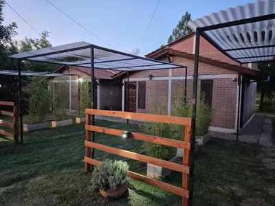 a wooden fence with a canopy in a yard at Cabañas Eduviges in Mina Clavero