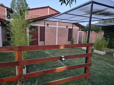 a wooden fence in front of a house at Cabañas Eduviges in Mina Clavero