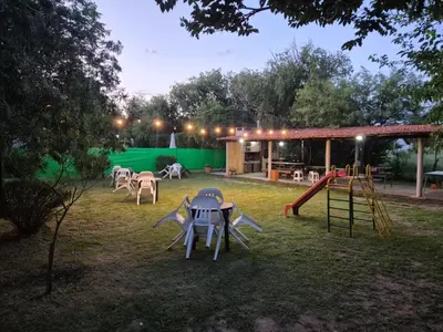 a backyard with a playground with a table and a slide at Cabañas Eduviges in Mina Clavero