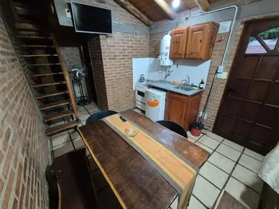 a small kitchen with a wooden table in a room at Cabañas Eduviges in Mina Clavero