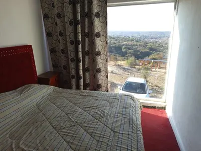 a bedroom with a bed and a window with a car at CABAÑA Casa Saavedra in Tanti
