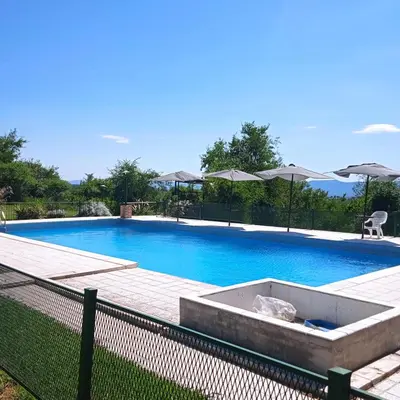 a large blue swimming pool with a wooden deck at CABAÑA Casa Saavedra in Tanti
