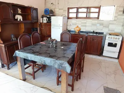 a kitchen with a table with chairs and a refrigerator at CABAÑA Casa Saavedra in Tanti