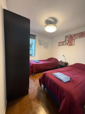a room with two beds and a door to a bedroom at Apartmento completo en Nueva Córdoba Argentina in Cordoba