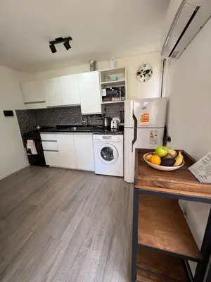 a kitchen with a refrigerator and a bowl of fruit on a counter at Apartmento completo en Nueva Córdoba Argentina in Cordoba