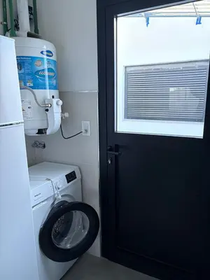 a bathroom with a toilet and a black door at Departamento macrocentro II, espacioso Río Cuarto in Río Cuarto