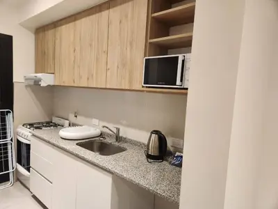 a kitchen with a sink and a microwave at Departamento macrocentro II, espacioso Río Cuarto in Río Cuarto