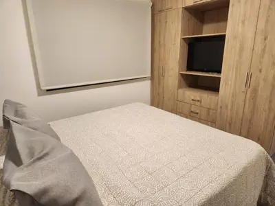 a bedroom with a bed and a cabinet with a television at Departamento macrocentro II, espacioso Río Cuarto in Río Cuarto