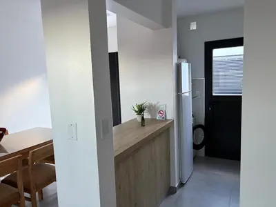 a kitchen with a counter and a refrigerator and a table at Departamento macrocentro II, espacioso Río Cuarto in Río Cuarto