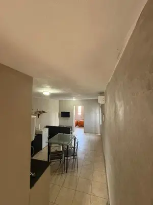 a living room with a table and a kitchen at Depto Maipu in Cordoba