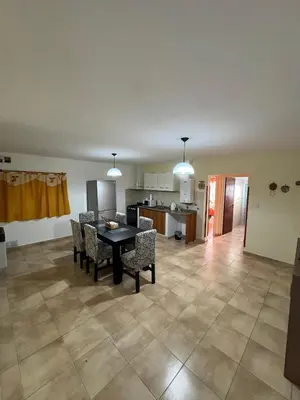 a living room with a table and chairs and a kitchen at Apart Dinkendein de 2 dormitorios in Río Cuarto