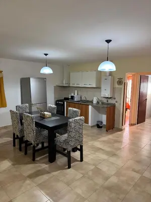 a kitchen and dining room with a table and chairs at Apart Dinkendein de 2 dormitorios in Río Cuarto