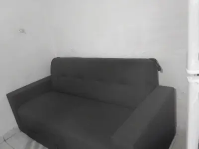 a black couch sitting in a corner of a room at El portal in Cordoba