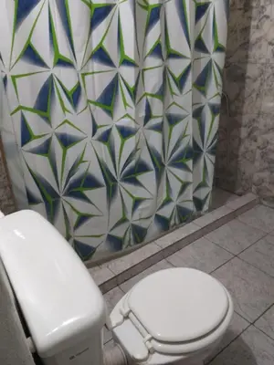 a bathroom with a toilet and a tiled wall at El portal in Cordoba