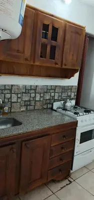a kitchen with wooden cabinets and a stove top oven at El portal in Cordoba